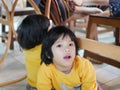 Little Asian baby girlÃ Â¸Â« sitting and playing / exploring with her younger sister under a dinning table at a restaurant Royalty Free Stock Photo